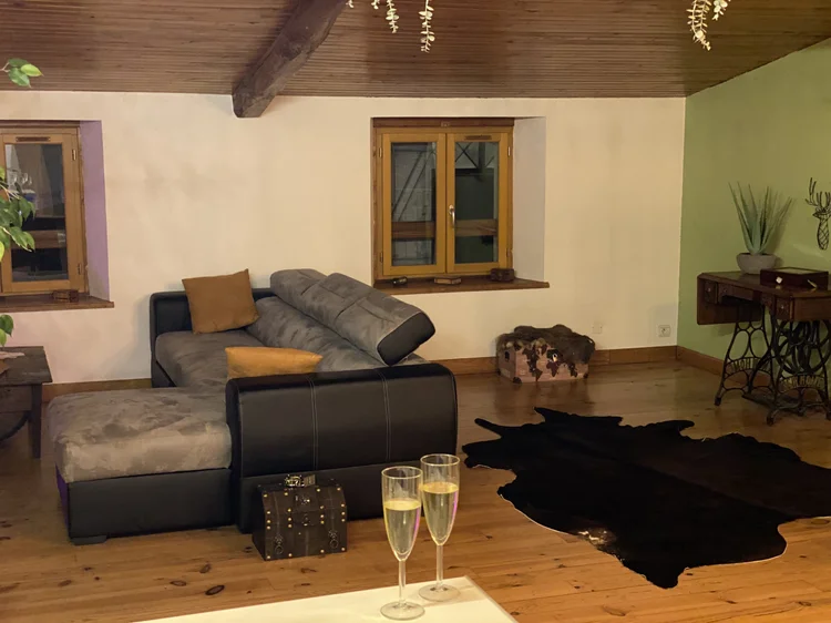 Le salon : canapé d'angle, peau de vache et deux coupes de champagne